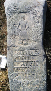 تصویر 6: گورنگاره شخصی ایستاده با لباس بلند و کلاه بر سر و تسبیحی در دست راست